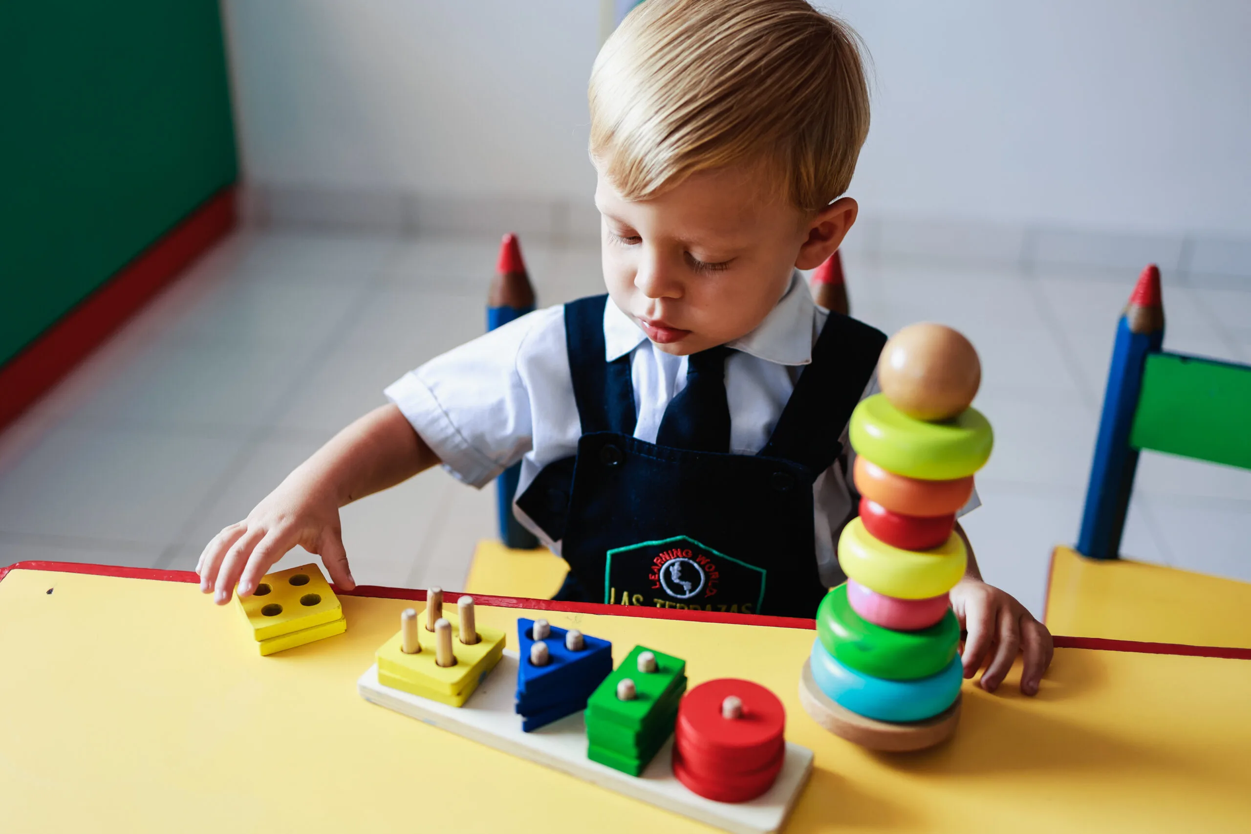 Niño pequeño jugando con bloques de madera educativos en el Preescolar Las Terrazas