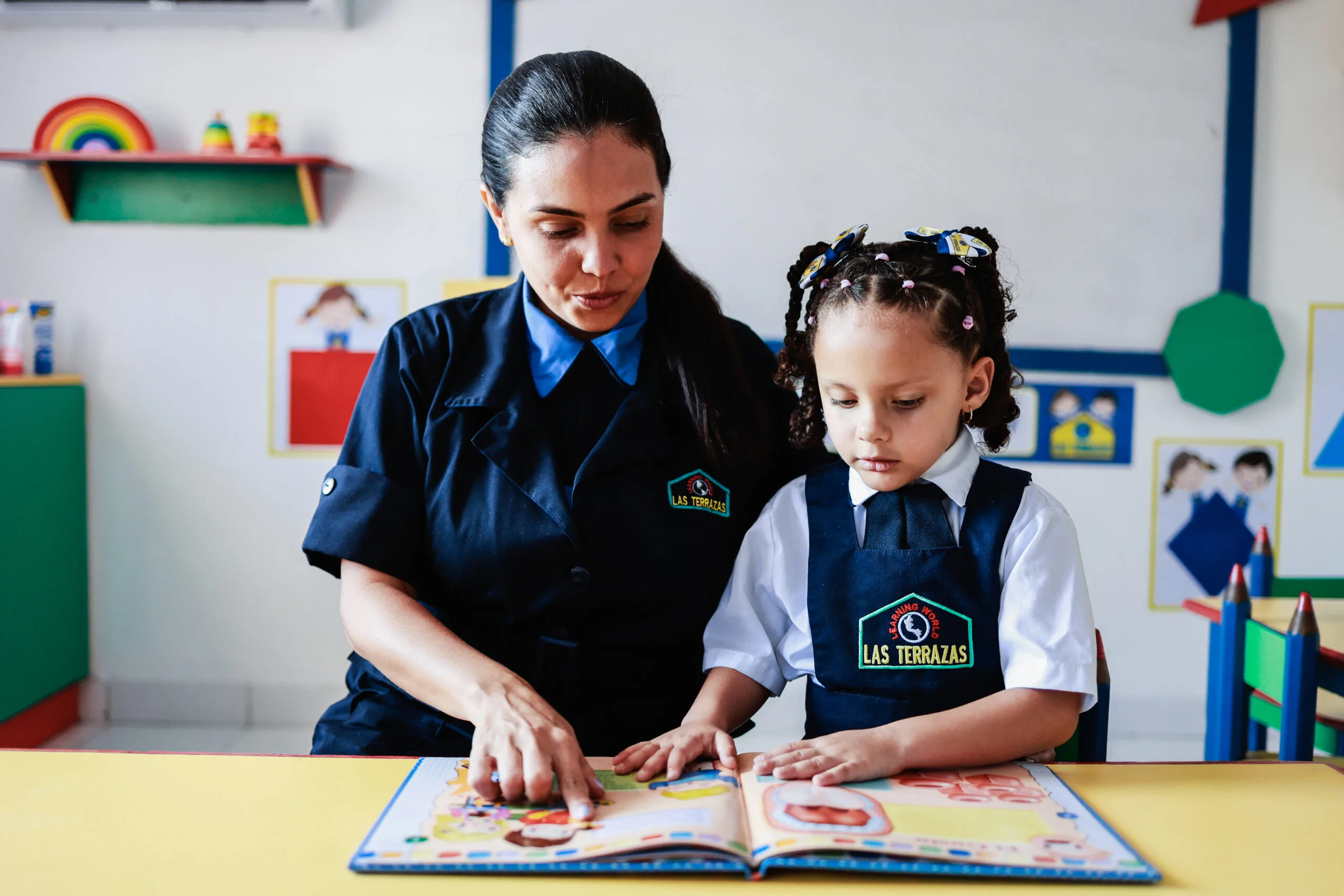 Maestra de Preescolar Las Terrazas enseñando a leer a una niña en el aula
