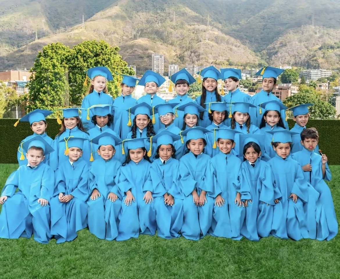 Grupo de niños graduados de preescolar en el Preescolar las Terrazas en Caracas con togas y birretes azules