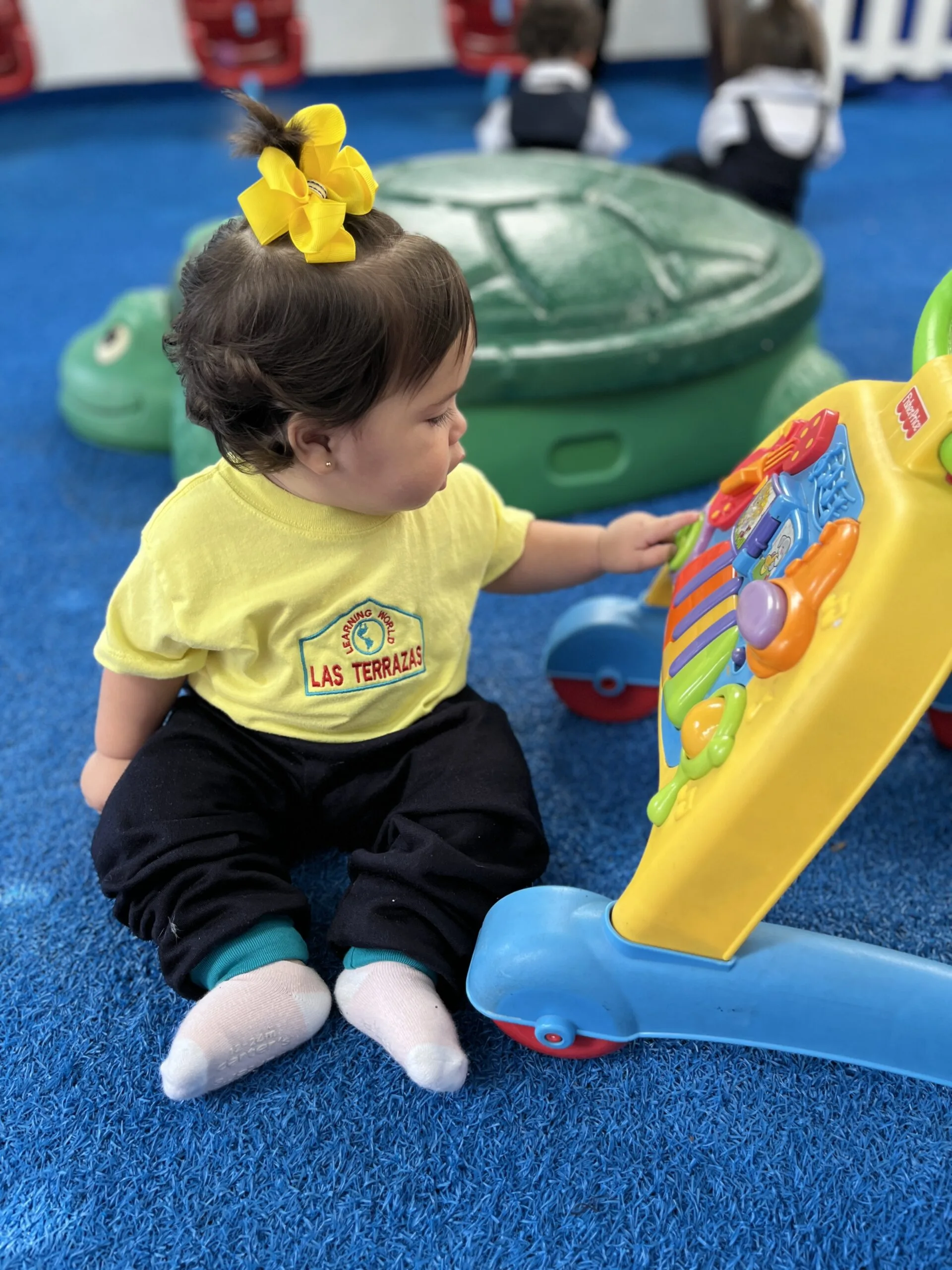Bebé jugando con un centro de actividades educativo en el preescolar Las Terrazas en Caracas